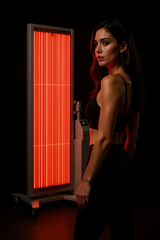 Woman standing beside the Zenapura GlowLift Red Light Therapy Panel in a dark setting, showcasing full body red and near infrared light for skin rejuvenation and wellness.