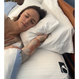 Woman peacefully sleeping on Zenapura organic cotton grounding earth grounding bed sheets with silver thread for earthing, EMF protection, and improved sleep quality.