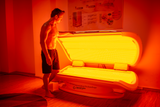 Man standing beside the Zenapura MaxiLUX Red Light Therapy Bed, preparing for a full-body red and near red light therapy session for skin rejuvenation, recovery, and wellness.